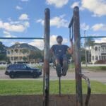 Doing pull ups at a calisthenics park